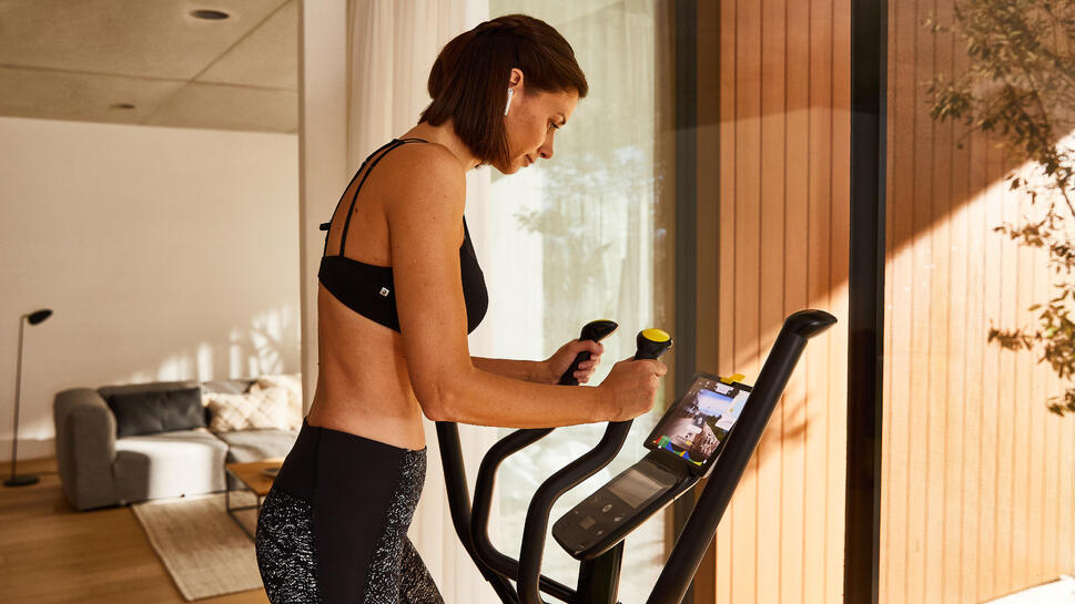Person using an elliptical cross trainer indoors