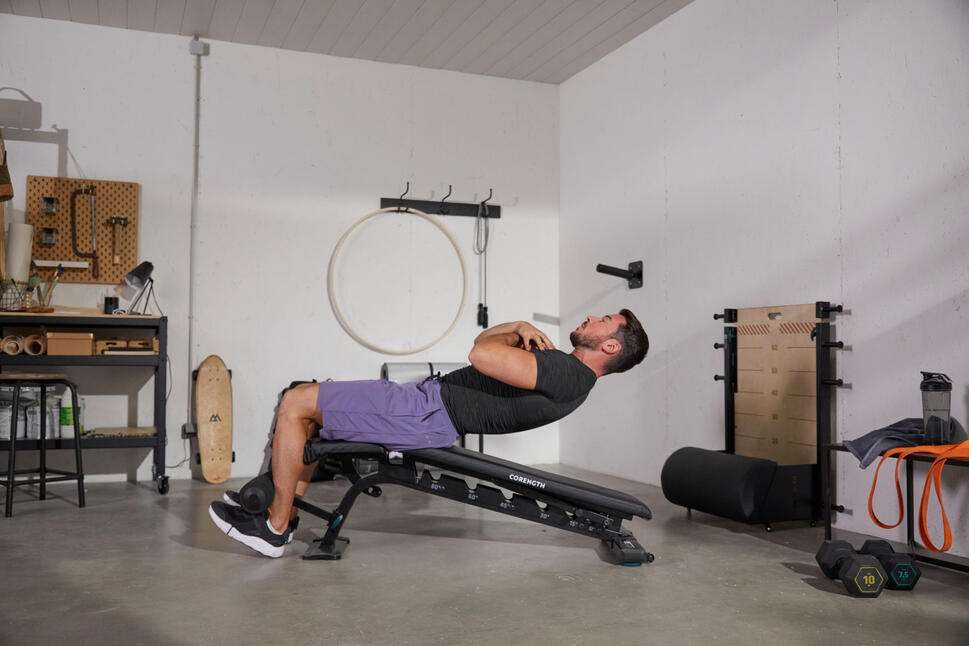 Person exercising on a gym bench with dumbbells