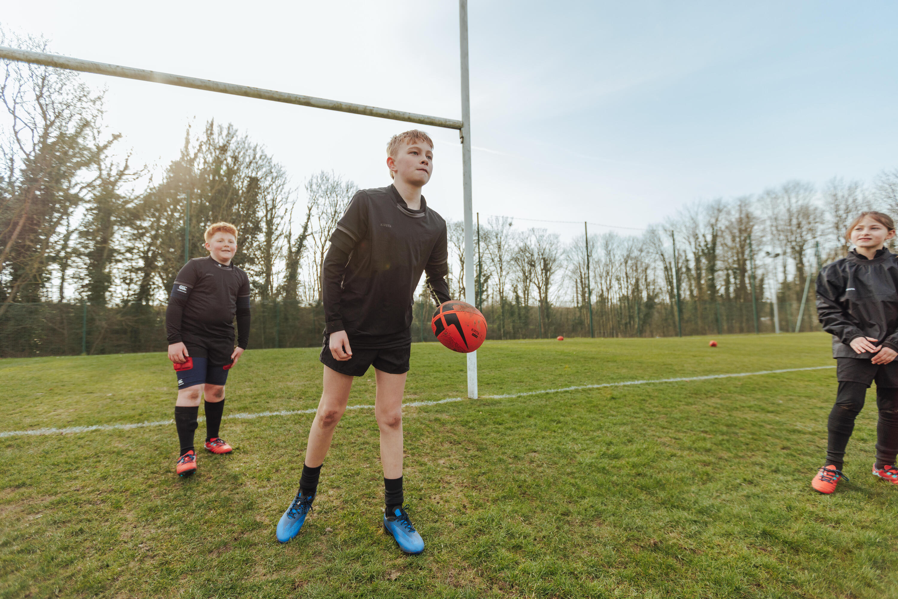 Player holding a rugby ball on the pitch