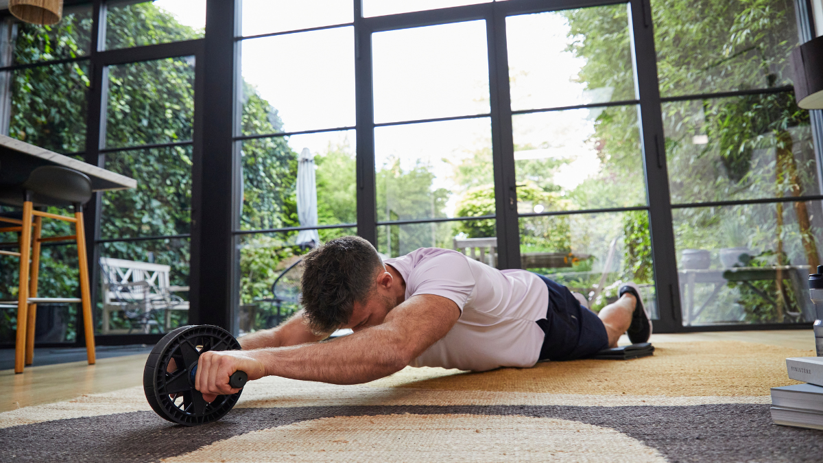 Person performing ab roller exercise on a mat