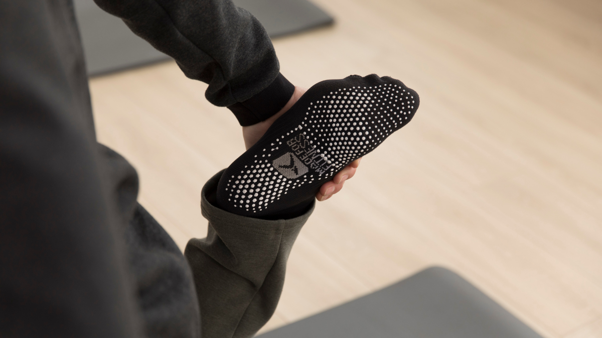 Woman wearing pilates socks on a mat